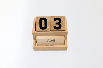 Close up of a wooden perpetual calendar showing the 3rd of April. Shot close up isolated on a white...