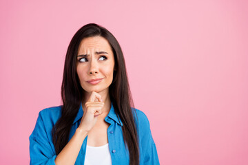 Photo of suspicious unsure girl with straight hairdo dressed blue shirt look empty space proposition isolated on pink color background