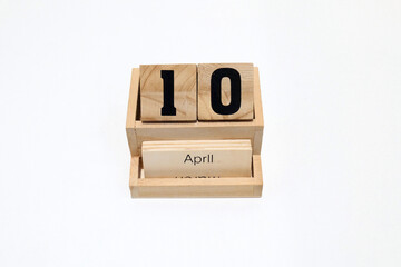 Close up of a wooden perpetual calendar showing the 10th of April. Shot close up isolated on a white background