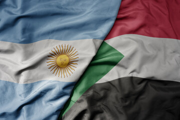big waving national colorful flag of sudan and national flag of argentina .