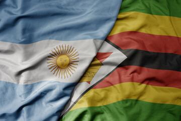big waving national colorful flag of zimbabwe and national flag of argentina .