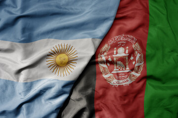 big waving national colorful flag of afghanistan and national flag of argentina .