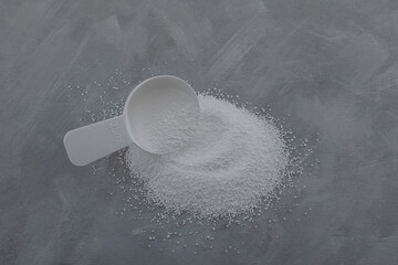Sodium percarbonate or sodium carbonate peroxide in measuring spoon. White granulated powder,...