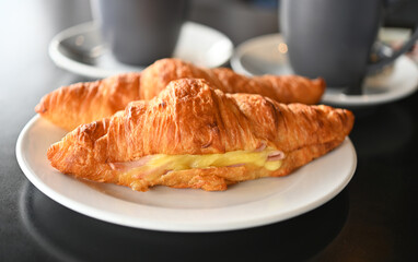 Breakfast view a bunch of croissant and two cups of hot coffee with cafe vibe background.