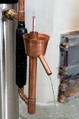 Close-up of alcohol distillation and brandy production with copper condenser. Traditional method of distilling whiskey, vodka and brandy.