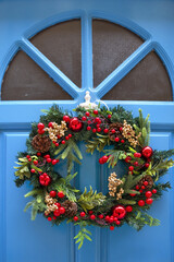 Wooden blue door with Christmas wreath in downtown of Birgu, Malta