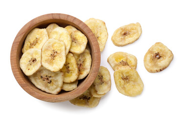 Banana chips in a wooden plate and scattered close-up on a white background. Top view