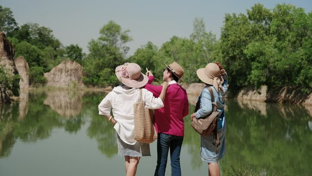 Three senior Asian women are best friends, come travel nature, relaxing, together after retirement, using pension money, Stand by water admire the atmosphere, beautiful natural views.