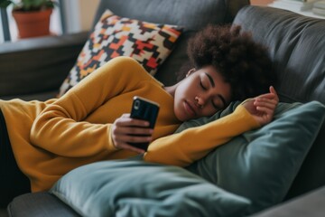 individual napped on the couch, phone in hand, texting paused