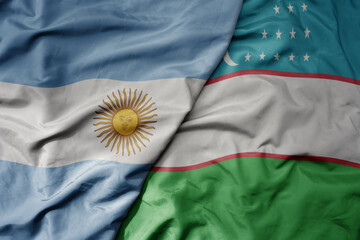 big waving national colorful flag of uzbekistan and national flag of argentina .