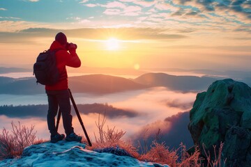 A lone mountaineer stands on a snow-covered mountain, gazing at the fiery sunset over a vast landscape, equipped with a trekking pole and filled with a sense of adventure and connection to nature - obrazy, fototapety, plakaty