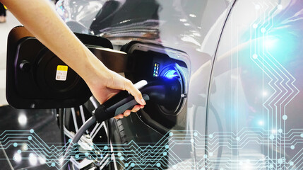 Woman hand holding a black cable plug while charging an electric car battery, new innovative...