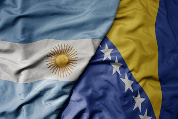 big waving national colorful flag of bosnia and herzegovina and national flag of argentina .