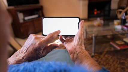 Old woman at home using a mobile phone with white screen. Mockup device