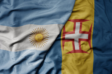 big waving national colorful flag of madeira and national flag of argentina .