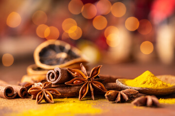 various spices and dried orange slices, lights on bokeh background. Still life