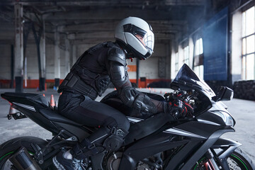 Biker wearing protective helmet and uniform for speed riding at training class - obrazy, fototapety, plakaty