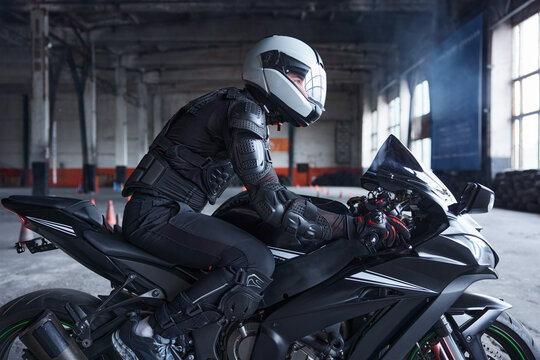 Biker wearing protective helmet and uniform for speed riding at training class
