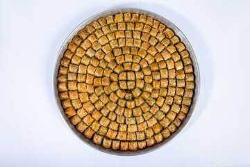 Top view of baklava on small tray isolated on white background.
