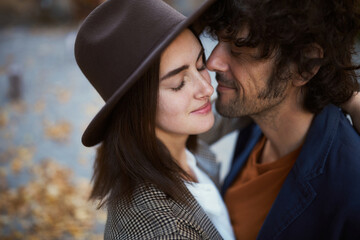 Close up portrait of charming couple in love on the streets. A man tenderly touches his girlfriend cheek, romantic moments with authentic emotions - 724851055