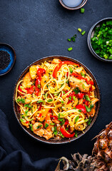 Stir fryed egg noodles with chicken, pineapple, paprika, green onion, soy sauce and sesame seeds in...