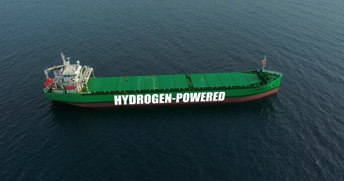 A large green ship in the blue ocean is carrying important cargo. The tanker uses hydrogen energy. Renewable energy for cargo transportation. Shipping is the engine of trade around the world