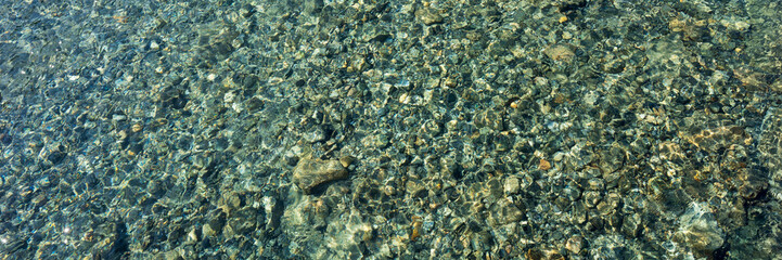 Panoramic image. Stones in the clear river water