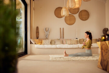 Side view of a focused female meditating at home with her eyes closed.