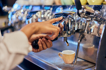 Close-up of a barista making an espresso at work, using a machine.