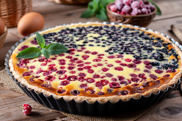 Raspberry and blueberry pie on a wooden table, close up