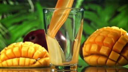 Fresh mango juice is poured into a glass. Filmed on a high-speed camera at 1000 fps. High quality FullHD footage - Powered by Adobe