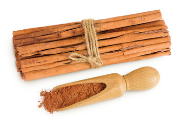 Cinnamon sticks with powder in wooden scoop isolated on white background with full depth of field. Top view. Flat lay.