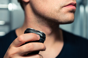 Shaving beard with machine. Man with electric shaver. Trimmer for face hair. Male grooming razor....