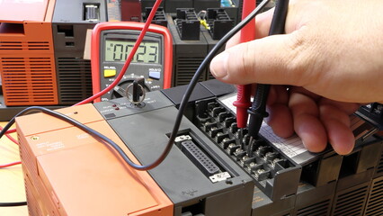 An electrical engineer measures the voltage on the control system. Soft focus, blurred background....