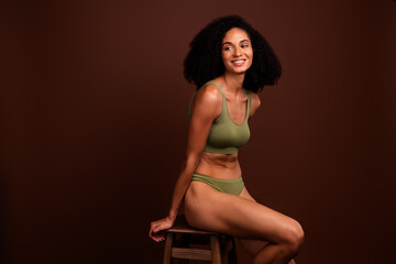 No filter photo of cheerful charming woman loving her body perfect shape feeling confident khaki lingerie isolated brown color background