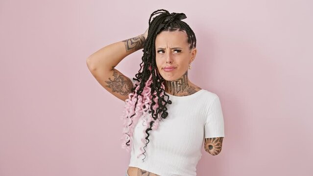 Pensive hispanic amputee woman standing over pink isolated background, wondering with doubt, armless but thinking, displaying uncertain concept.