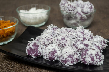 Klepon ubi ungu is a snack made of purple sweet potato filled with palm sugar and covered with grated coconut. one of the most popular traditional cakes in Indonesia