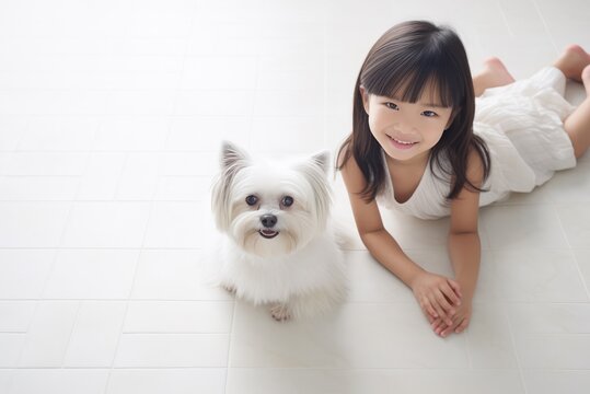 A cute girl posing with her little dog. a light photo. the concept of friendship with a pet