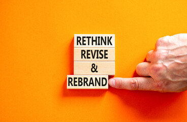 Rethink revise rebrand symbol. Concept word Rethink Revise and Rebrand on beautiful block. Beautiful orange background. Business brand motivational rethink revise rebrand concept. Copy space.
