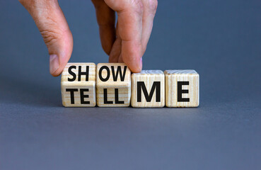 Tell or show me symbol. Businessman turns beautiful wooden cubes and changes words Tell me to Show...