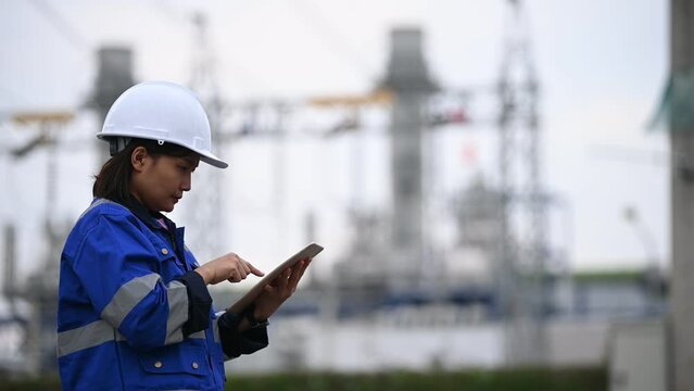 Asian woman petrochemical engineer working at oil and gas refinery plant industry factory,The people worker man engineer work control at power plant energy industry manufacturing