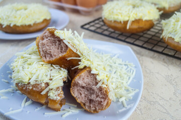 Donat ubi ungu or purple sweet potato donuts. made from purple sweet potato with a sprinkling of cheese on top. has a soft texture