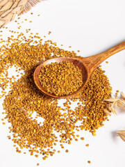Flower pollen in wooden spoon on white background. Natural bee products