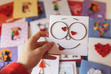 Hand holding quilling card with cute face in love. Happy valentine day. woman making greeting...