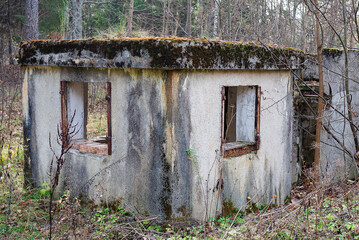 Abandoned concrete booth in the autumn forest.