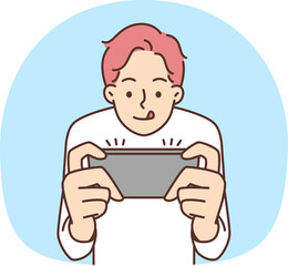 Guy have fun playing video game on cellphone. Addicted small child look at smartphone screen involved in digital reality.