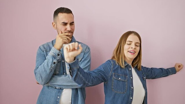 Beautiful couple in a denim shirt standing yawning with a tired yawn, hand over mouth signaling sleep. terrified of boredom under sleepiness. jaded love on an isolated pink background.
