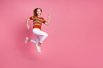 Full size profile photo of energetic overjoyed girl jump run empty space ad isolated on pink color...