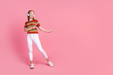 Fototapeta premium Full size photo of carefree positive person dancing enjoy listen music headphones empty space isolated on pink color background