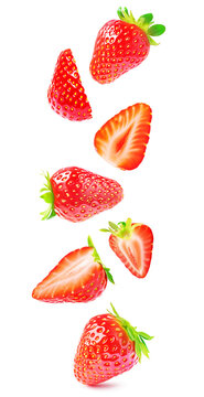Cut fresh strawberries with slices flying isolated against white background